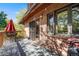 Relax on this comfortable deck with outdoor table and seating alongside the home's red brick exterior at 1810 Youngfield Ct # A, Golden, CO 80401