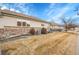 Backyard showing brick foundation, vinyl siding, and manicured lawn at 2616 E Egbert St, Brighton, CO 80601