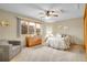 Cozy bedroom with a large window, ceiling fan, and a relaxing sitting area at 2616 E Egbert St, Brighton, CO 80601