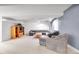 Basement living room featuring plush seating, light gray carpet, TV and modern lighting fixture at 2616 E Egbert St, Brighton, CO 80601