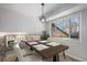 Bright dining room with a wooden table set for four near the wrought iron railing overlooking the living room at 6527 S Ammons Ct, Littleton, CO 80123