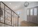 Bright foyer featuring decorative staircase, stylish front door with glass accents, and wood-look floors at 6527 S Ammons Ct, Littleton, CO 80123