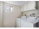 Laundry room with white cabinetry, utility sink, and washer and dryer at 6527 S Ammons Ct, Littleton, CO 80123