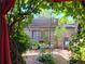 Shaded backyard retreat featuring a red curtain, wooden fence and table with foliage at 2541 Cherry St, Denver, CO 80207