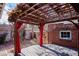 Backyard deck with a pergola, red drapes and a brick wall at 2541 Cherry St, Denver, CO 80207