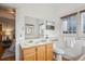 Bright bathroom features a sink, toilet, and a large mirror, next to the bedroom at 2541 Cherry St, Denver, CO 80207