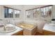 Classic bathroom with yellow tub, sink and wood trim, featuring multiple windows at 2541 Cherry St, Denver, CO 80207