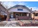 Charming brick home featuring a covered front porch and a well-maintained front yard at 2541 Cherry St, Denver, CO 80207