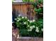 A tranquil garden view featuring white peonies, a wooden fence, and a charming bench at 2541 Cherry St, Denver, CO 80207