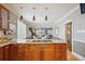 Kitchen island with wood cabinets and granite countertops with gas range, open to the living room at 2541 Cherry St, Denver, CO 80207