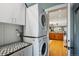 Modern laundry room with stacked washer and dryer next to a countertop with gray and white tiles at 2541 Cherry St, Denver, CO 80207