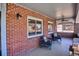 Inviting covered porch featuring brickwork, comfortable seating, and a ceiling fan at 2541 Cherry St, Denver, CO 80207