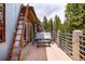 Exterior deck featuring patio swing overlooking the forest with metal rails and a ladder at 167 Independence Cir, Breckenridge, CO 80424