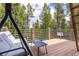 Comfortable deck includes a cushioned swing set and a table with chairs, surrounded by towering trees at 167 Independence Cir, Breckenridge, CO 80424