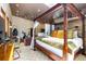 Bedroom featuring a four-poster bed, sitting area, stone accent wall, and a ceiling fan at 167 Independence Cir, Breckenridge, CO 80424