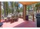 Covered outdoor dining area features a table, seating and BBQ grill amongst a wooded setting at 167 Independence Cir, Breckenridge, CO 80424