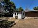 View of backyard with detached structure and sunny area, framed by mature trees at 8319 Quivas Way, Denver, CO 80221