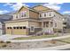 Two-story home featuring a two-car garage, stone accents, and a welcoming front porch with a tidy lawn at 10913 Ledges Rd, Parker, CO 80134
