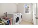 Bright laundry room equipped with modern washer and dryer units, maximizing efficiency and convenience at 10913 Ledges Rd, Parker, CO 80134