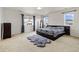 Bright main bedroom with plush carpet, large windows, and a dark wood platform bed frame at 10913 Ledges Rd, Parker, CO 80134
