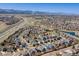 Expansive aerial view of a suburban neighborhood with tree-lined streets and mountain views at 8888 S Dudley St, Littleton, CO 80128