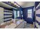 Well-lit blue bathroom featuring double sinks, tile flooring and modern lighting at 8888 S Dudley St, Littleton, CO 80128