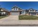 Charming two-story home with gray siding, brick accents, a well-manicured lawn, and an attached two-car garage at 8888 S Dudley St, Littleton, CO 80128