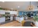 Bright kitchen with white cabinets, stainless steel appliances, hardwood floors, and an open layout to the living area at 8888 S Dudley St, Littleton, CO 80128