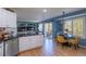 Stylish kitchen with white cabinetry, hardwood floors, stainless steel appliances, and an adjacent breakfast nook at 8888 S Dudley St, Littleton, CO 80128