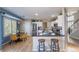 Eat-in kitchen features stainless appliances, white cabinetry, hardwood floors, and a breakfast bar at 8888 S Dudley St, Littleton, CO 80128