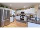 Bright kitchen featuring stainless steel appliances, white cabinetry, and hardwood floors at 8888 S Dudley St, Littleton, CO 80128