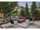 Inviting backyard patio with a modern fire pit, comfortable seating, and lush landscaping at 14 S Grape St, Denver, CO 80246