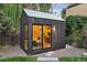 Charming backyard studio with modern design and large glass windows surrounded by lush greenery and gravel landscaping at 14 S Grape St, Denver, CO 80246