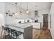 Contemporary kitchen featuring an island with bar seating, white subway tile, and wood floors at 14 S Grape St, Denver, CO 80246