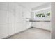 Bright laundry room features sleek, all-white cabinetry, modern sink, and a view from the window at 14 S Grape St, Denver, CO 80246