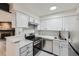 Renovated kitchen featuring stainless steel appliances, white cabinets, and marble countertops with fireplace view at 11913 E Harvard Ave # 106, Aurora, CO 80014