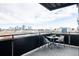 Balcony with city views, a black metal railing, and a small table with two chairs at 2880 Zuni St # 308, Denver, CO 80211