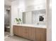 Bright bathroom featuring double sinks, wooden cabinets, and a glass-enclosed shower at 2880 Zuni St # 308, Denver, CO 80211
