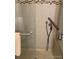 Bathroom shower with tiled walls, glass door, and a grab bar at 9060 E Cherry Creek South Dr # E, Denver, CO 80231