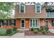 Charming brick home featuring a bay window, lush landscaping, and a cozy entryway at 9060 E Cherry Creek South Dr # E, Denver, CO 80231