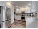 Well-lit kitchen with stainless steel appliances, subway tile backsplash and white cabinets at 9060 E Cherry Creek South Dr # E, Denver, CO 80231
