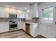 Well-lit kitchen showcasing stainless steel appliances, granite countertops, and white cabinets at 9060 E Cherry Creek South Dr # E, Denver, CO 80231