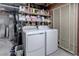 Laundry room with washer and dryer and built-in storage shelves above units at 9060 E Cherry Creek South Dr # E, Denver, CO 80231