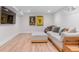 Relaxing basement with seating, stylish posters, and hardwood floors at 1568 S Dudley Ct, Lakewood, CO 80232