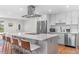 Stylish kitchen featuring stainless steel appliances, white cabinets, and a large island with seating at 1568 S Dudley Ct, Lakewood, CO 80232
