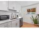 Bright kitchen featuring white cabinets, stainless steel appliances, and a modern faucet at 1568 S Dudley Ct, Lakewood, CO 80232