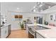 Bright kitchen with stainless steel appliances, white cabinets, and an island with cooktop and breakfast bar at 1568 S Dudley Ct, Lakewood, CO 80232