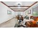 Spacious living room with exposed beams, cozy seating and a dining room in the background at 16308 E Wyoming Dr, Aurora, CO 80017