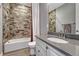 Bathroom featuring textured tile in the shower, a modern vanity, and bronze fixtures at 11796 Edenfeld St, Parker, CO 80134