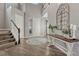 Bright foyer with hardwood floors, a decorative table, and staircase leading to the upper level of the house at 11796 Edenfeld St, Parker, CO 80134